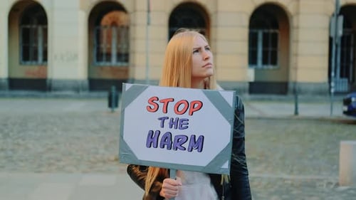 Une femme blonde proteste pour mettre fin au mal en tenant un bateau à vapeur