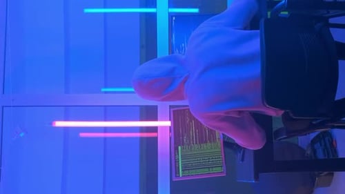 Vue arrière d'un hacker criminel travaillant le soir sur un ordinateur dans un grand bureau
