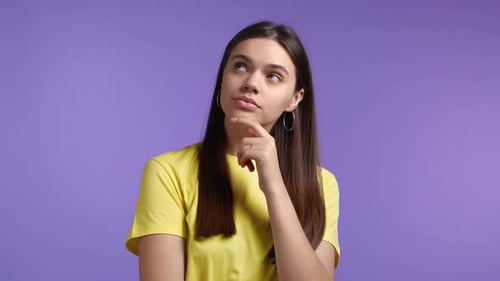 Thinking Woman Looking Up and Around on Violet Studio Background