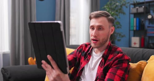Young Adult Video Chatting on Tablet at Home