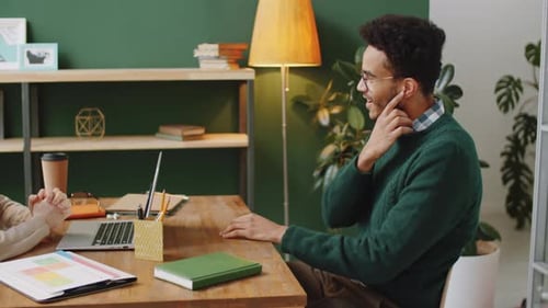 Male and Female Business Partners Speaking in Office