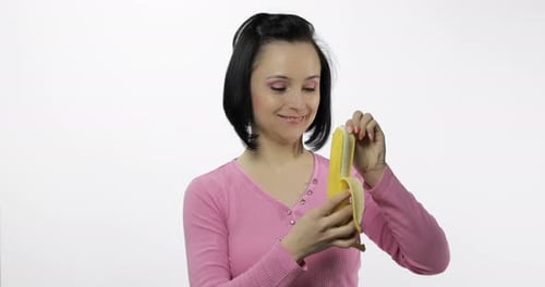 Woman Peeling and Eating Fresh Yellow Banana