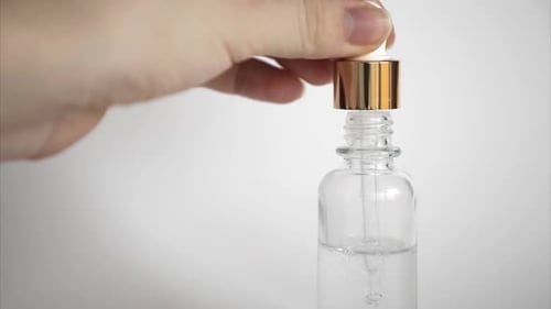 Hyaluronic Acid Drop Falls From Cosmetic Pipette on White Background, Dropper Glass Bottle Mock-Up