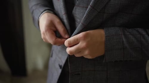 Man Fastening Buttons of a Classy Gray Suit