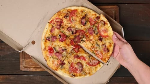 Hand Reaches for Slice of Pizza