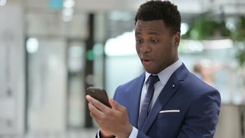 Excited Young Adult Celebrates Success on Phone