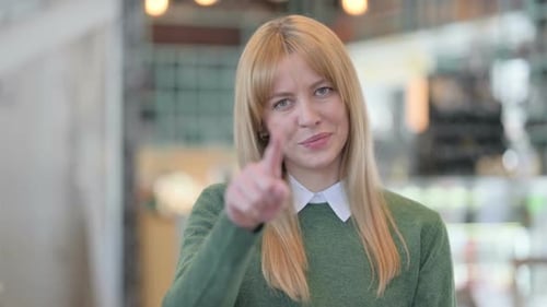 Blonde Woman Points to Camera With a Smile