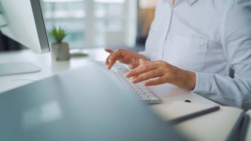 Woman Typing on Keyboard in Office Workplace