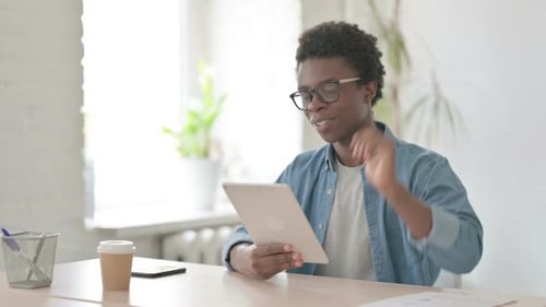 Online Video Chat on Tablet By Young African Man in Office