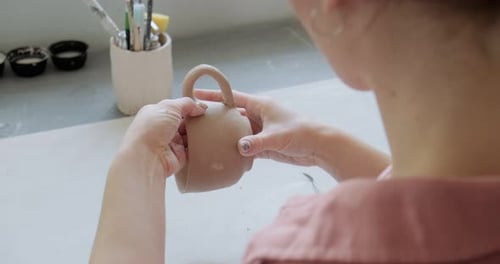 Artist Shaping Clay Mug in Pottery Studio