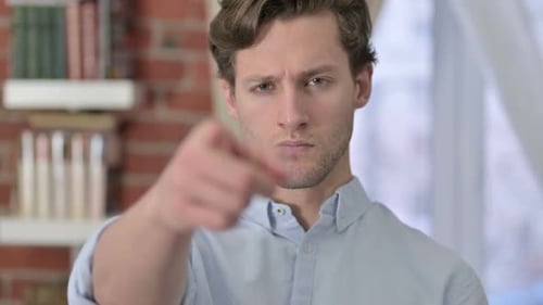 Man Points Index Finger Straight Ahead in Room