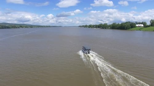 aerial passing pontoon boat on the move 4k