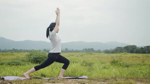 Woman Practicing Yoga Outdoors in Grassy Field