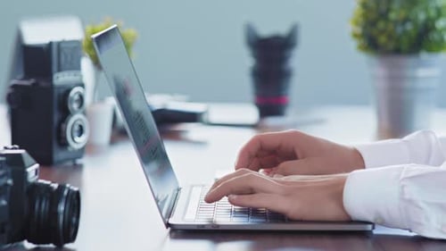Hands Typing on Laptop in Modern Workplace