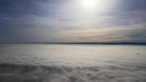 Luftaufnahme aus großer Höhe der Erde, bedeckt mit weißen, geschwollenen Cumuluswolken an einem sonnigen Tag
