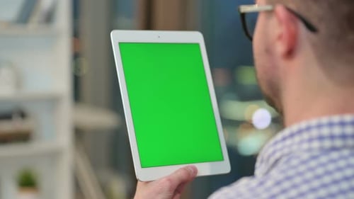 Rear View of Young Man Using Tablet with Chroma Key Screen