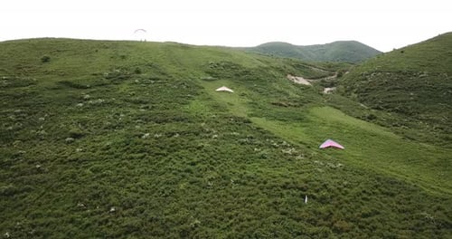 Scenic Aerial View of Paragliders on Green Hills