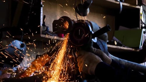 Close Up Of Worker Cutting Metal With Grinder