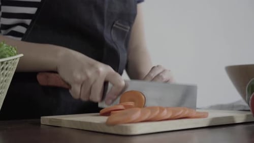 woman making salad healthy food and chopping carrot on cutting boar