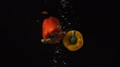 Bell Peppers Falling Slowly Into Water