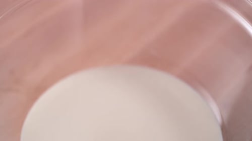 Egg Yolk Splashing into Bowl of Creamy Milk