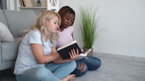 Two Friends Reading Books Together Indoors
