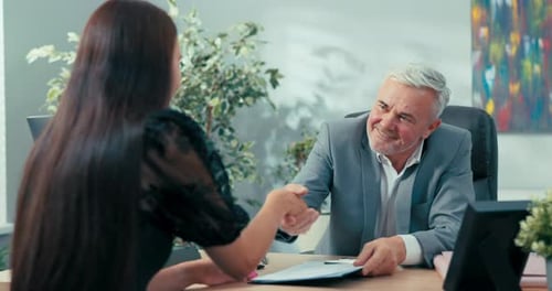 Der reife Chef des Unternehmens unterzeichnete einen Vertrag mit einem neuen Mitarbeiter, einem Kandidaten für die Position des Assistenten