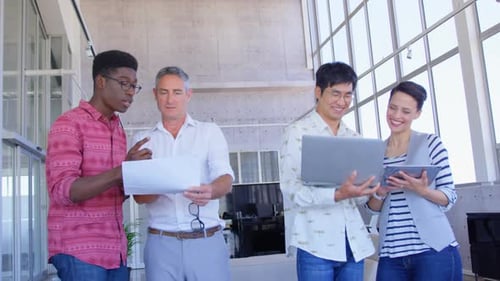 Multi-ethnic business people discussing over document and laptop in modern office 4k