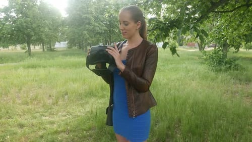 Girl Is Looking For A Virtual Reality Helmet In The Park