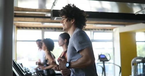 Group of Young People Running on Treadmills in Sport Gym
