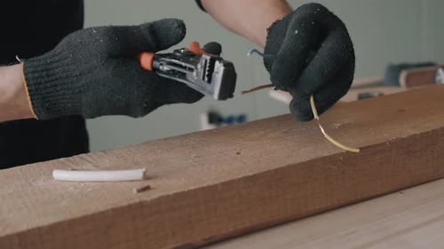 Man Using Wire Strippers on Copper Wire