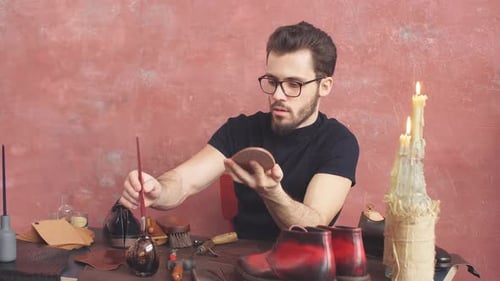 Young Designer Using a Brush While Working in Shoe Shop with Modern Interior