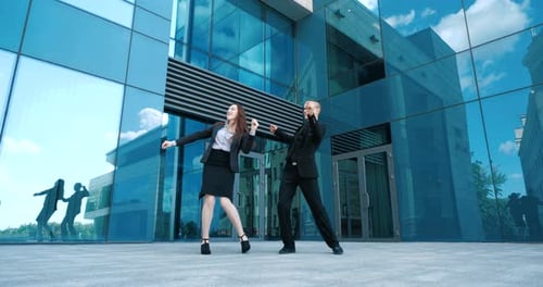 Joyful Young Adults Dance Near Modern Office Building