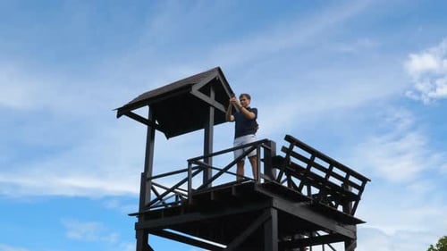 Man Taking Pictures from Tropical Observation Tower