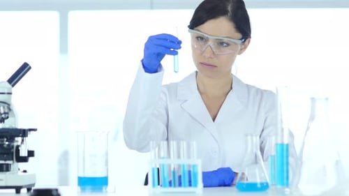 Scientist Analyzing Liquid in Laboratory Setting