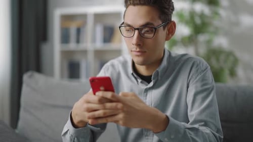 Man Using Smartphone While Sitting on Sofa