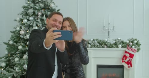 Festive Couple Taking Christmas Selfies at Home