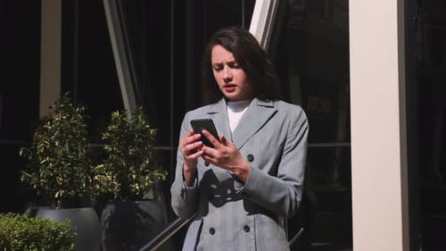 Pretty Upset Woman Using Phone in the Street