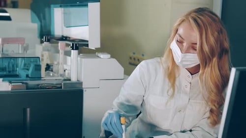 Female Lab Worker Analyzing Blood Sample in Test Tube