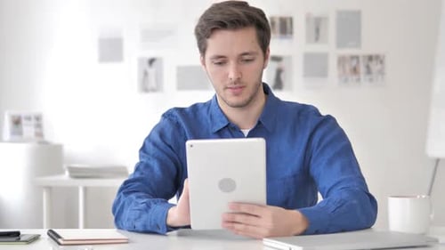 Man Looking at Tablet, Cheering in Office