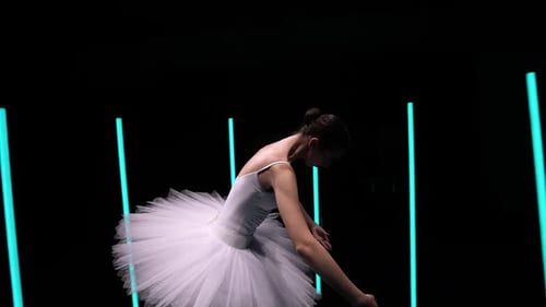 La cámara gira alrededor de una sensual bailarina con tutú blanco que baila elementos del ballet Clásica