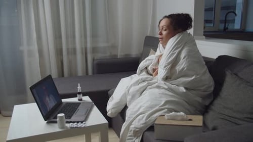 Woman Has Telehealth Appointment Wrapped in Blanket