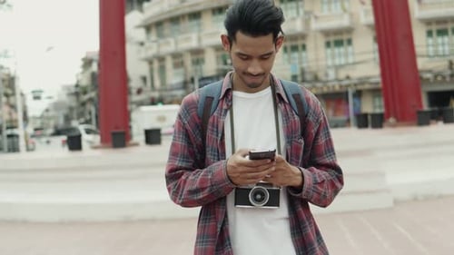 Smiling Man Using Smartphone in an Urban Setting