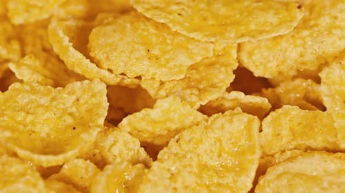 Golden Corn Flakes for Breakfast on Rotating Background. Food Ingredient Background. Top View