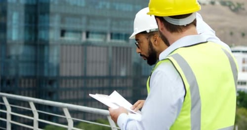 Architects discussing over blueprint