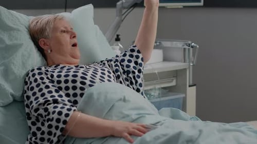 Senior Woman Receives Oxygen Mask in Hospital Bed