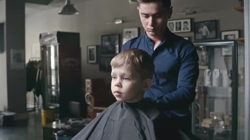 Young Adult Giving Child a Haircut