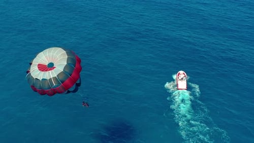 Luftaufnahme. Fliegen mit Fallschirm hinter einem Boot. Extremer Wassersport im Meer. Parasailing.