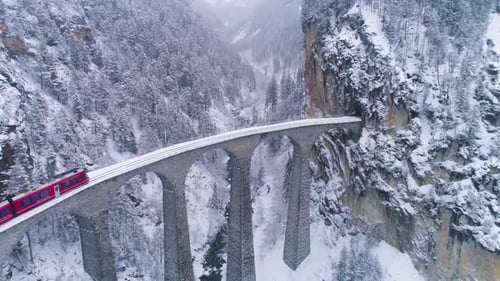 Viaduc de Landwasser avec chemin de fer et train le jour d'hiver. Il neige. Suisse. Vue aérienne