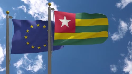 European Union and Togo Flags Waving in Blue Sky with Clouds